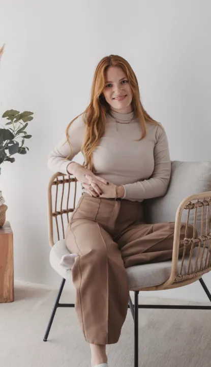 Nadine Stievermann sitzt lächelnd in einem Rattansessel